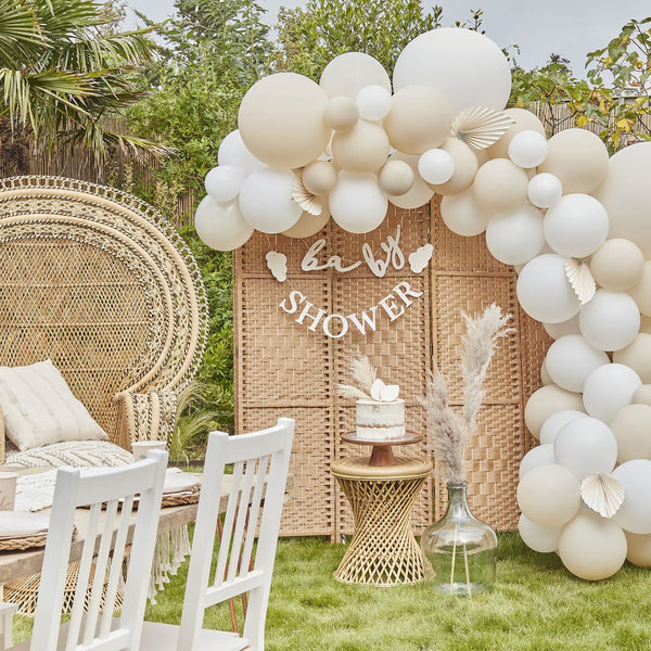 Nude and white balloon decorating arch kit with palm spear fans
